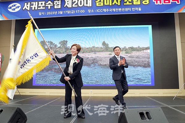 김미자 조합장이 취임식에서 조합기를 흔들고 있다.
